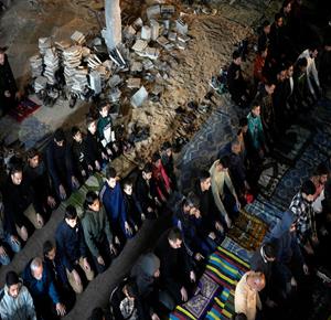 مواطنون يؤدون صلاة التراويح في الليلة الأولى من شهر رمضان على أنقاض مسجد الكنز المدمر في مدينة غزة